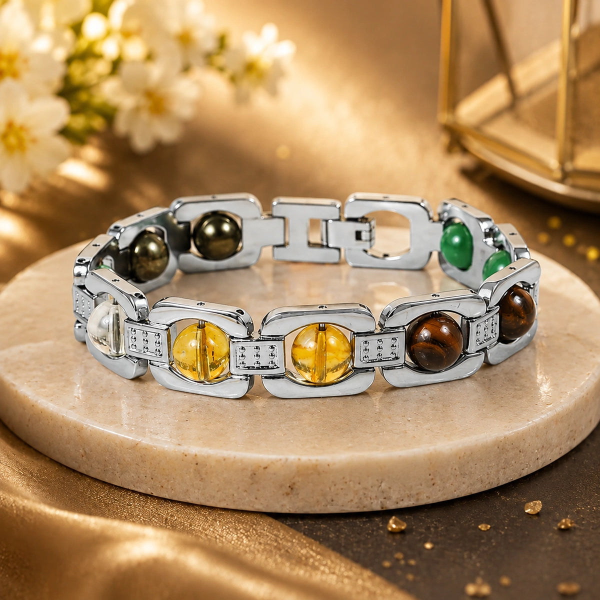 A polished silver-tone link bracelet with multiple round gemstone accents in amber, green, brown, and clear, displayed on a round beige stone slab with a warm golden background.